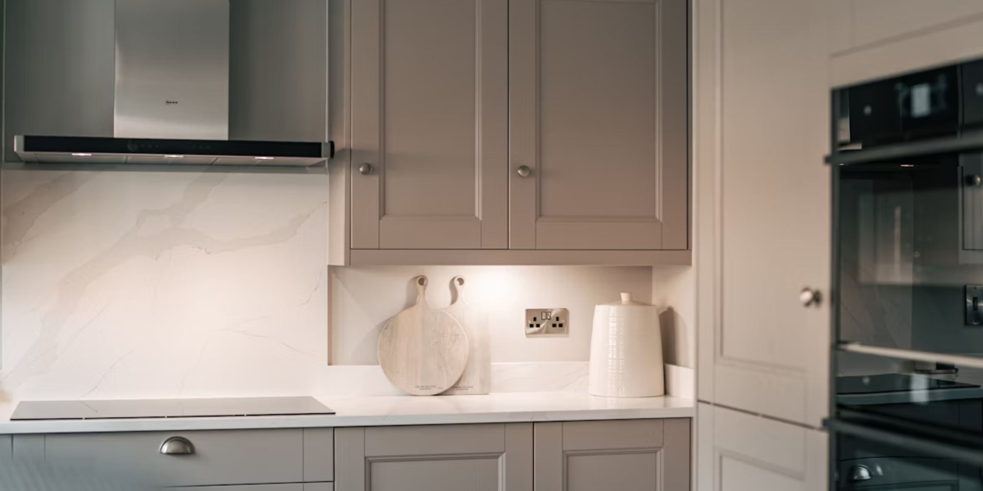Small Kitchen with white marble effect tile splashback and beige cabinetry