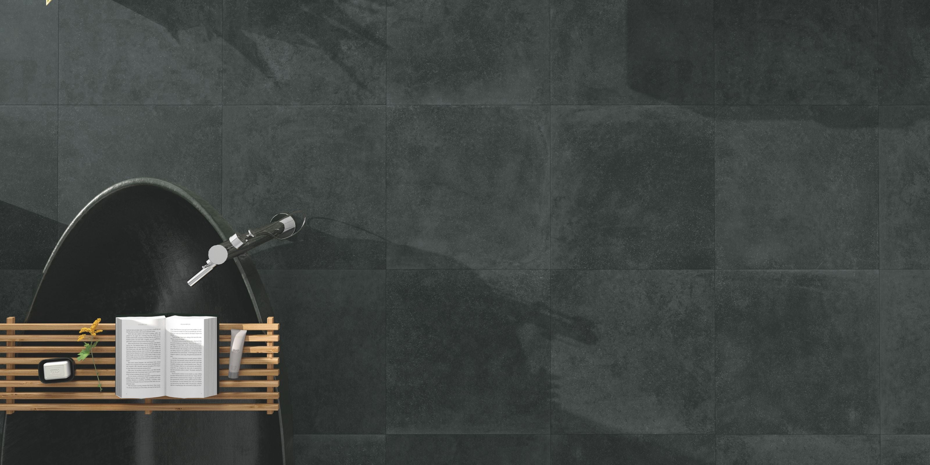 birdseye view of a large bathtub and the dark grey matt stone effect bathroom floor tiles surrounding it
