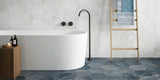 bathroom with a bathtub and white stone effect hexagonal wall tiles and patterned blue  hexagonal porcelain floor tiles