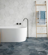 bathroom with a bathtub and white stone effect hexagonal wall tiles and patterned blue  hexagonal porcelain floor tiles