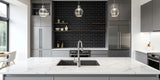 Kitchen with a large marble top island and a backplash wall with black subway wall tiles