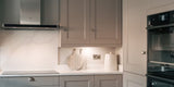 Small Kitchen with white marble effect tile splashback and beige cabinetry