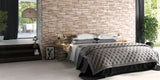bedroom with natural stone split face wall tiles behind bed