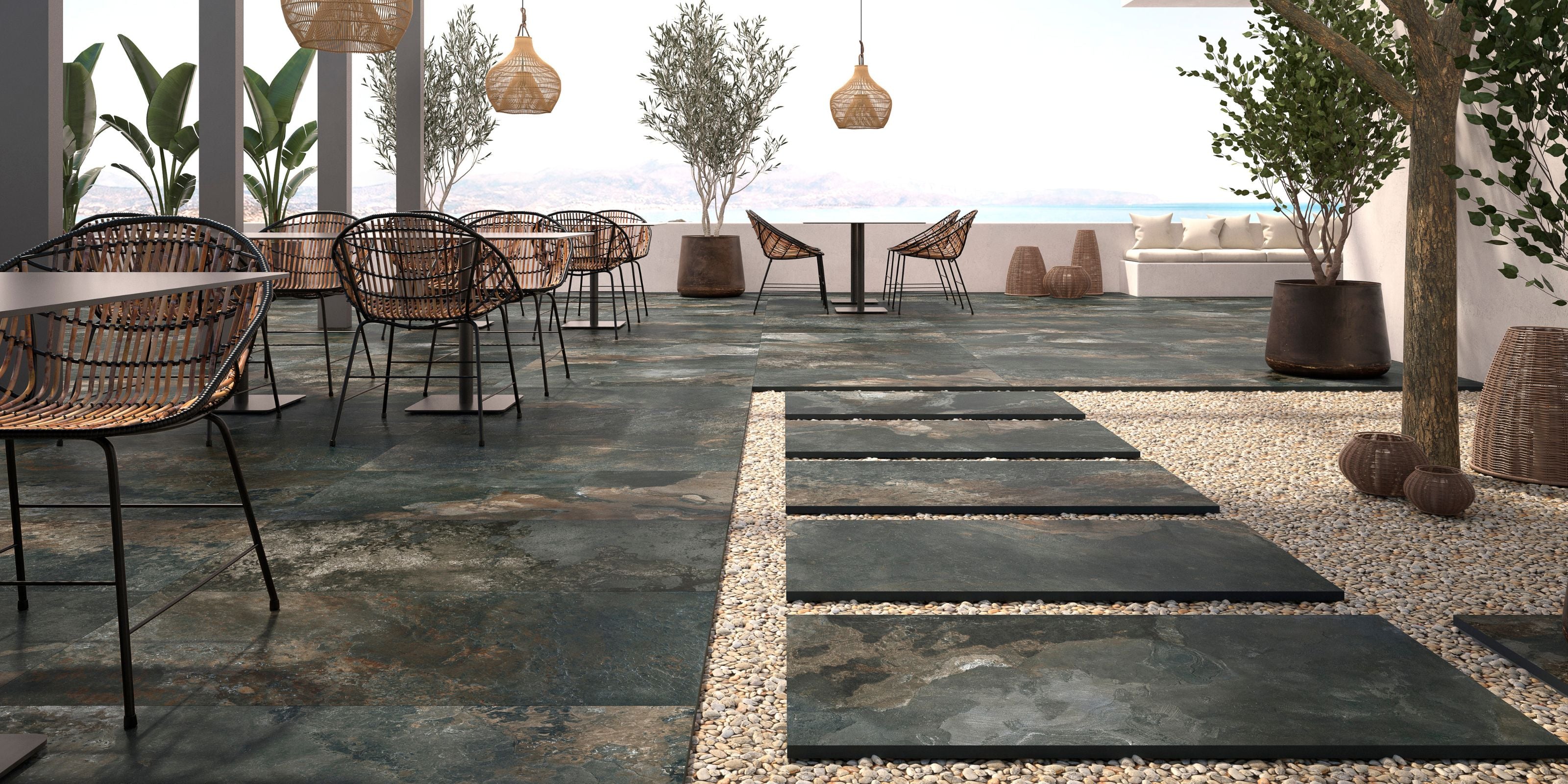 Outdoor dining area with matt dark grey 20mm stone effect porcelain outdoor floor tiles.